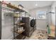 Convenient laundry room equipped with shelving and a front loading washer and dryer at 702 Yucatan Dr, Waxhaw, NC 28173