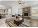 Open living room with stone fireplace, neutral sofa and hardwood floors at 702 Yucatan Dr, Waxhaw, NC 28173