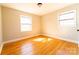 Bright bedroom featuring hardwood floors, neutral walls, and natural light from two windows at 7231 Lockmont Dr, Charlotte, NC 28212