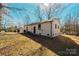 Back of house with a white brick exterior, dark trim, and a large, grassy yard at 7231 Lockmont Dr, Charlotte, NC 28212