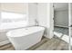 Bathroom featuring modern standalone tub under a bright window; updated flooring visible in attached bedroom at 801 Requa Rd, Cherryville, NC 28021
