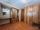 Cozy bedroom featuring a mirrored closet and wood-paneled walls at 103 Dogwood Cir, New London, NC 28127