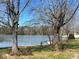 Picturesque waterfront view framed by mature trees, featuring a dock extending into the serene lake at 103 Dogwood Cir, New London, NC 28127