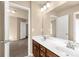 Bathroom featuring a double sink vanity with modern fixtures, a large mirror, and a doorway leading to a bedroom at 11502 Wilson Mill Ln, Pineville, NC 28134