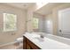 Bright bathroom featuring a single sink vanity and mirror with a window and toilet at 11502 Wilson Mill Ln, Pineville, NC 28134