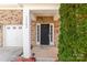 Close-up of the home's entrance featuring a black front door and a well-lit, welcoming porch at 11502 Wilson Mill Ln, Pineville, NC 28134