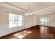 Bright living room featuring large windows, wainscoting and chandelier at 11502 Wilson Mill Ln, Pineville, NC 28134