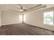 Large main bedroom with a tray ceiling, ceiling fan, and many windows at 11502 Wilson Mill Ln, Pineville, NC 28134