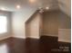 A bonus room features hardwood floors, a ceiling fan, and ample natural light from the window at 1220 Avalon Pl, Matthews, NC 28104