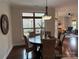 Bright dining area with a modern chandelier, woven chairs, and a view to an outdoor patio at 1220 Avalon Pl, Matthews, NC 28104