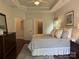 Well-lit main bedroom with a tray ceiling, connected bath, and hardwood floors at 1220 Avalon Pl, Matthews, NC 28104