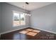Bright dining room with hardwood floors, modern chandelier, and large window overlooking the yard at 1282 Beal Rd, Lincolnton, NC 28092
