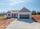 A new construction home is shown with an attached garage and concrete driveway at 1282 Beal Rd, Lincolnton, NC 28092