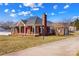 Charming brick home featuring a classic design, mature landscaping, and a welcoming front porch at 130 Ketchie Dr, Mooresville, NC 28115