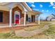 Inviting brick home with a covered front porch, white columns, and a red front door at 130 Ketchie Dr, Mooresville, NC 28115