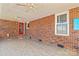 Covered porch area featuring tile flooring, brick walls, and a red door at 130 Ketchie Dr, Mooresville, NC 28115