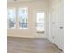 A bright bedroom has wood-look floors, white walls, and large windows with black railings outside at 1307 Cerium Way, Charlotte, NC 28211