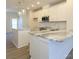 A bright kitchen has white cabinets, stainless steel appliances, marble countertops, and wood-look flooring at 1307 Cerium Way, Charlotte, NC 28211