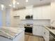 Modern kitchen featuring stainless steel appliances, granite countertops, and white cabinetry at 1307 Cerium Way, Charlotte, NC 28211