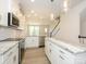 An open kitchen with white cabinets, marble countertops, stainless appliances, and wood-look flooring at 1307 Cerium Way, Charlotte, NC 28211