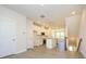 Open floor plan connects living space to kitchen with white cabinets, marble counters, and stainless appliances at 1307 Cerium Way, Charlotte, NC 28211