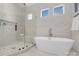 Bright bathroom with a glass shower, freestanding tub, and marble tiling at 144 Sardis Ln, Charlotte, NC 28270