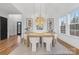 Elegant dining room with modern chandelier, light wood table, and white chairs, ideal for Gathering gatherings at 144 Sardis Ln, Charlotte, NC 28270