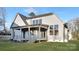 Rear exterior of home featuring a covered porch and well maintained lawn at 144 Sardis Ln, Charlotte, NC 28270