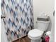 Bathroom featuring a toilet with blue patterned shower curtain and storage shelves at 1461 Forkhorn Dr, Monroe, NC 28110