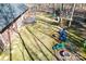Aerial view of a backyard with a treehouse, playground, and patio area at 1601 Rosegate Ln, Stanfield, NC 28163