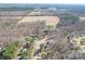 Aerial view of a landscaped property in a wooded area with a pool at 1601 Rosegate Ln, Stanfield, NC 28163