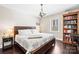 Comfortable bedroom with a king-size bed, hardwood floors, natural lighting, and built-in shelving at 1601 Rosegate Ln, Stanfield, NC 28163