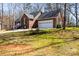 View of a brick home with a two-car garage and a well-manicured lawn surrounded by trees at 1601 Rosegate Ln, Stanfield, NC 28163