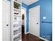 Hallway featuring hardwood floors, shelving storage, and white trim at 1601 Rosegate Ln, Stanfield, NC 28163