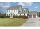 Charming white two-story home with attached garage and well-manicured lawn on a sunny day at 2027 Gloucester St, Matthews, NC 28104
