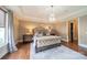 Beautifully appointed main bedroom with tray ceiling, chandelier and wood floors at 2027 Gloucester St, Matthews, NC 28104