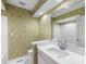 Bathroom with decorative wallpaper, a single sink vanity, and white tiled shower at 2027 Meadowood Ln, Charlotte, NC 28211
