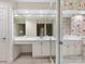 Well-lit bathroom with dual sinks, a vanity area, large mirrors, and stylish wallpaper at 2027 Meadowood Ln, Charlotte, NC 28211