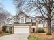 Charming two-story home featuring a brick and gray siding exterior, attached garage and manicured lawn at 2027 Meadowood Ln, Charlotte, NC 28211