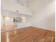 Bright living room with hardwood floors leading to a mirrored landing at 2027 Meadowood Ln, Charlotte, NC 28211