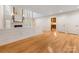 Open living room showcasing beautiful hardwood floors and access to another room with built-ins at 2027 Meadowood Ln, Charlotte, NC 28211