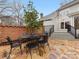 Spacious stone patio with black metal outdoor furniture and a partial view of the home's exterior at 2027 Meadowood Ln, Charlotte, NC 28211