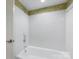 Bright, white tiled shower with decorative wallpaper trim and chrome fixtures at 2027 Meadowood Ln, Charlotte, NC 28211