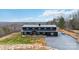 Attractive black barndominium-style home with a metal roof, set against a backdrop of rolling hills at 2288 Boheler Rd, Clover, SC 29710