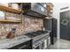 Gourmet kitchen boasts a professional-grade range, custom hood, and unique brick backsplash, blending style and performance at 2288 Boheler Rd, Clover, SC 29710