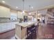 Bright, open kitchen with a large central island, white cabinetry and hardwood floors and barstool seating at 2729 Duncan Ave, Charlotte, NC 28205
