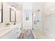 Bathroom featuring white vanity with double sinks and frameless shower with white subway tile at 40934 Deer Haven Dr, Albemarle, NC 28001