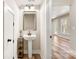 Stylish pedestal sink bathroom with a sleek mirror and wooden floors, offering a modern, minimalist design at 40934 Deer Haven Dr, Albemarle, NC 28001