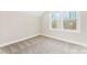 Bright bedroom with neutral carpet, white trim, and a large window for natural light at 40934 Deer Haven Dr, Albemarle, NC 28001
