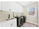 Laundry room featuring white cabinets, sink, and new washer and dryer at 40934 Deer Haven Dr, Albemarle, NC 28001